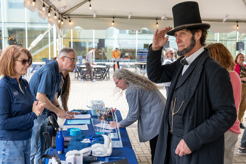 Abe Lincoln actor saluting at the check-in desk during Day of Giving Fest.