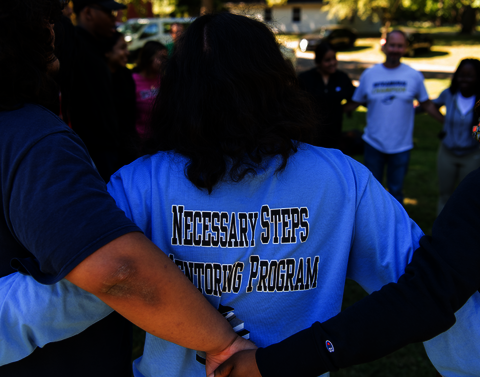 The back of someone's shirt that says, "Necessary Steps Mentoring Program."