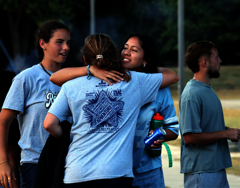 Two girls hugging in grey shirts.