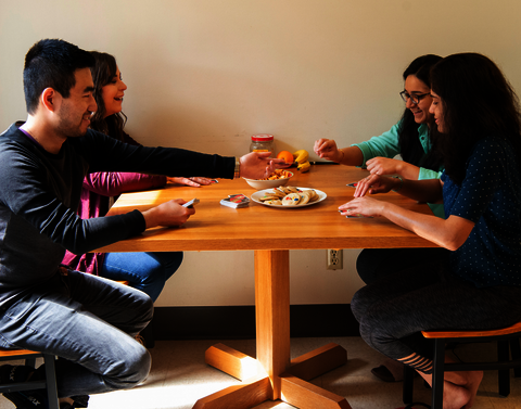 Four students sitting at a table for a snack.