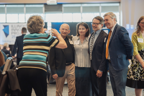 Group posing for a photo at an indoor event.