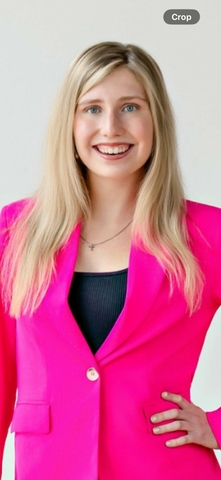 student posed in front of a beige background with a pink suit jackson