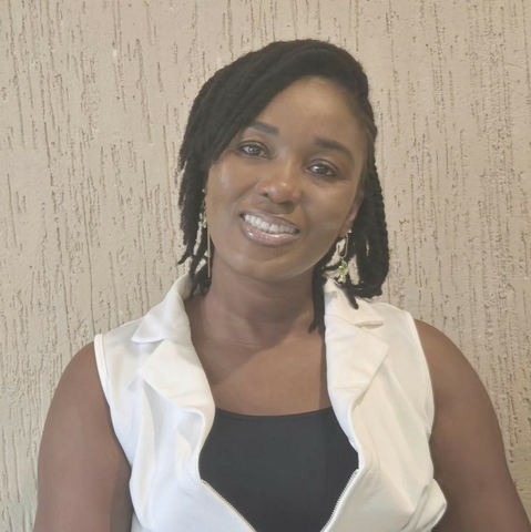 Smiling women with short black hair wearing a black tank top and white vest