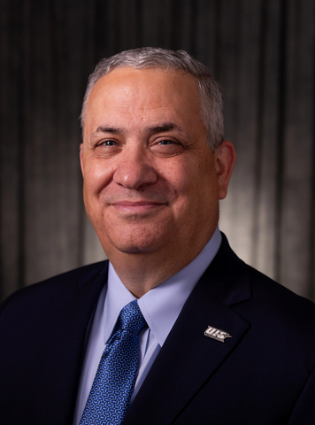 Mike Hermann, UIS director of athletics, poses for a professional headshot in a suit and blue tie.