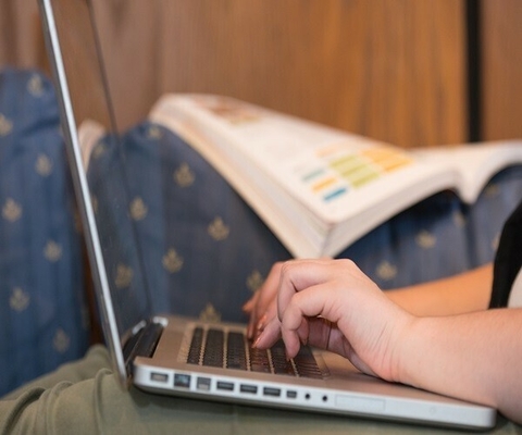 close up of student working on laptop