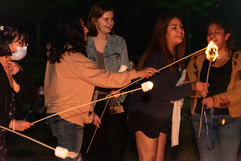 students making smores at a bonfire