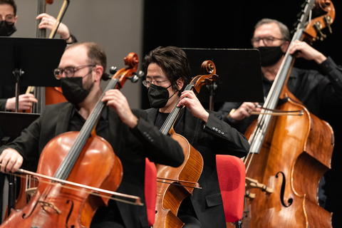 two cellists and a bass player playing indoors