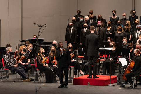orchestra and choir facing a conductor