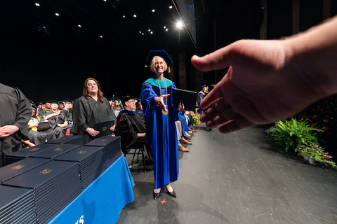 From your perspective, you are reaching out to shake the Chancellor's hand at graduation.