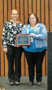 Ginger Mullin and Alexandra Scherba holding an award plaque