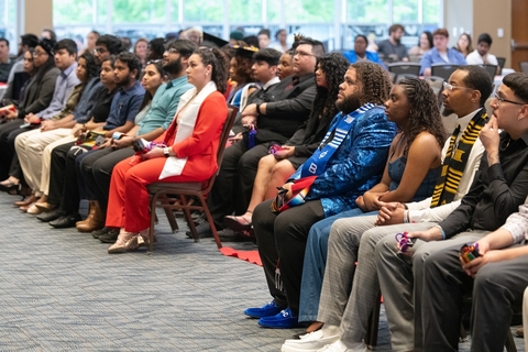 College students sitting down in rows of chairs.