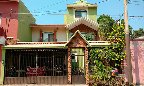 Three story house painted lime green, white and pink.