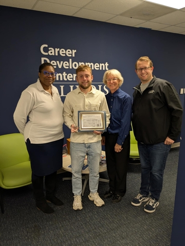 Andrew holding his award next to Dr. Clark