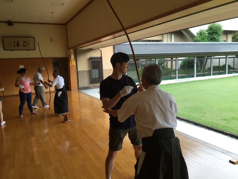 students receiving archery lessons from Japanese masters