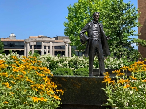 Abe Lincoln statue surrounded by yellow and white flowers