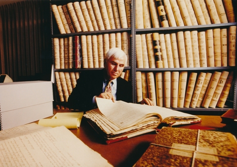 Cullom Davis looking at a deed book in the university archives