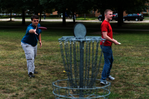 students playing disc golf