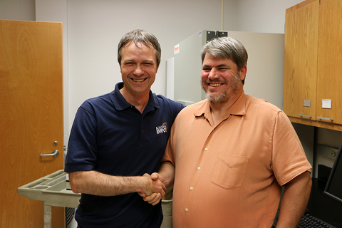 two men shaking hands over the donation of the HPLC
