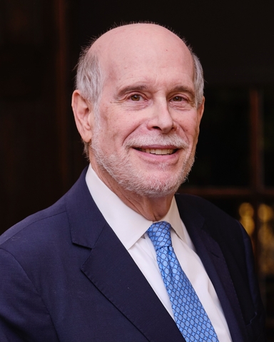 Portrait of Harold Holzer, smiling in a blue suit and patterned tie.