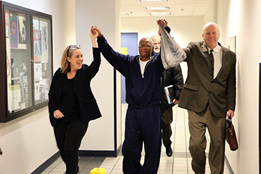 Charles Palmer walks with hands held up triumphantly.