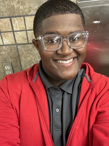 David Green wearing a red jacket and black polo.