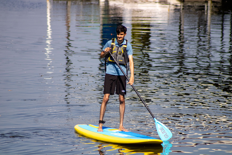 a male student standing up on a paddleboard