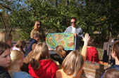 students with a map presenting it to children