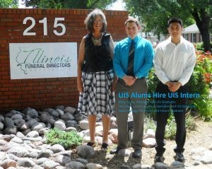 Three people standing in front of an 'Illinois Funeral Directors' sign.