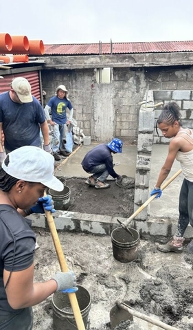 UIS students and staff mixing concrete for the flooring of the house in Guatemala