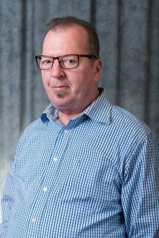 Brian Moore head-and-shoulders photo in button-down shirt.