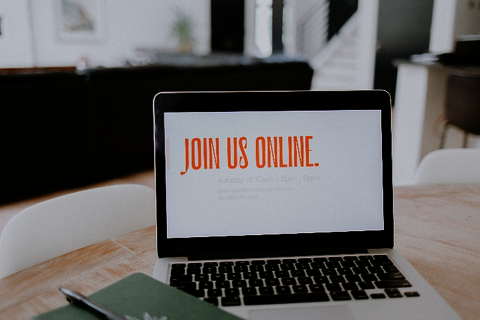 laptop with phrase
'join us online' on its desktop