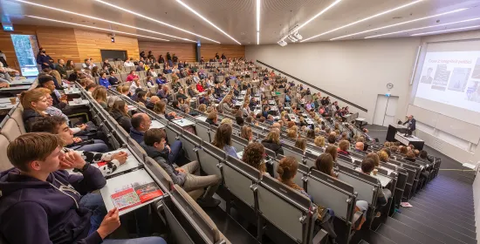 Students sitting in a large lecture hall.