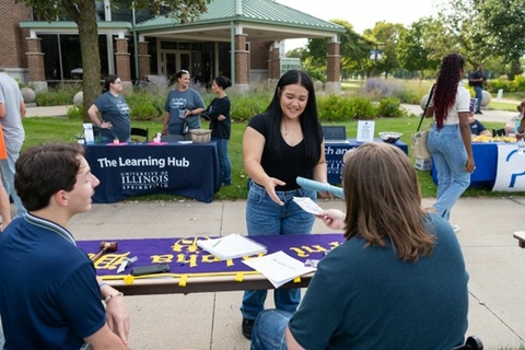 Student receiving papers at the Involvement Expo.