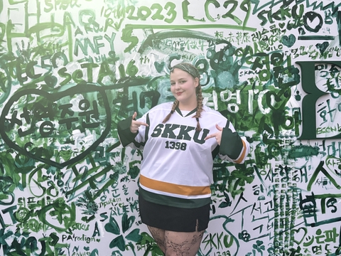 Mackenzie Bateman in front of graffiti wall wearing her SKKU jersey.