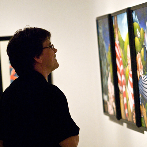 artist looking at artwork in Visual Arts Gallery