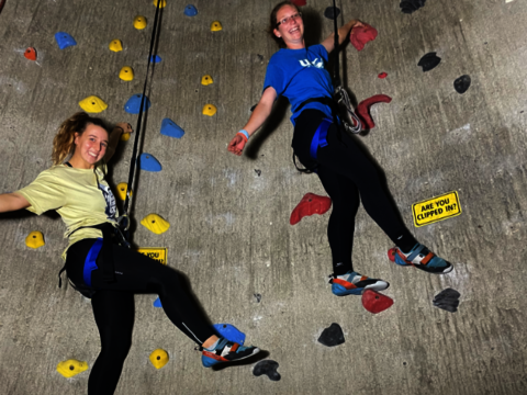 two female students rock climbing