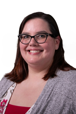 Professional photo of Shannon Stanley- female with dark brown shoulder-length hair with black rimmed glasses