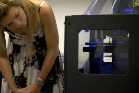 Student watching 3D printer print