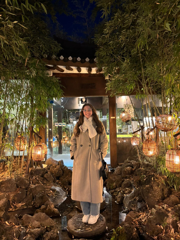 Gloria Bajlozi in front of a traditional South Korean building at night.