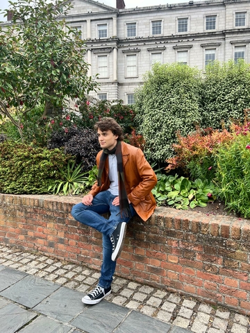 Brandon Raps posing in front of foliage.