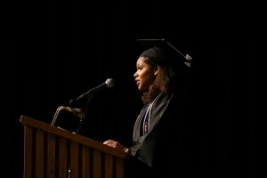 UIS graduate speaking at podium