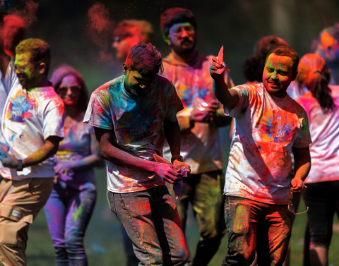 A group of students covered in multiple colors of powder