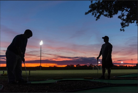students playing mini golf at night