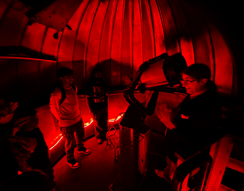 Students listen to Professor Martin in the Observatory next to the telescope.