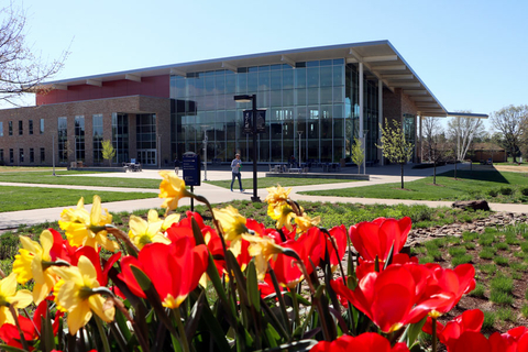 flowers blooming in the foreground with the Student Union in the background