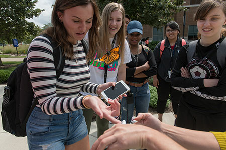students playing with a butterfly