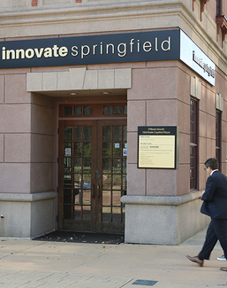 Two people walk past the entrance of Innovate Springfield, a UIS innovation hub in downtown Springfield, Illinois.