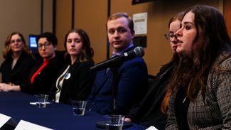 Group panel discussion with a woman speaking into a microphone.