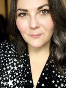 Woman looking at camera, wearing a star print dress.