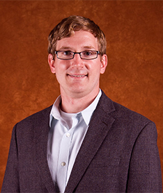 Man looking at camera wearing a suit.